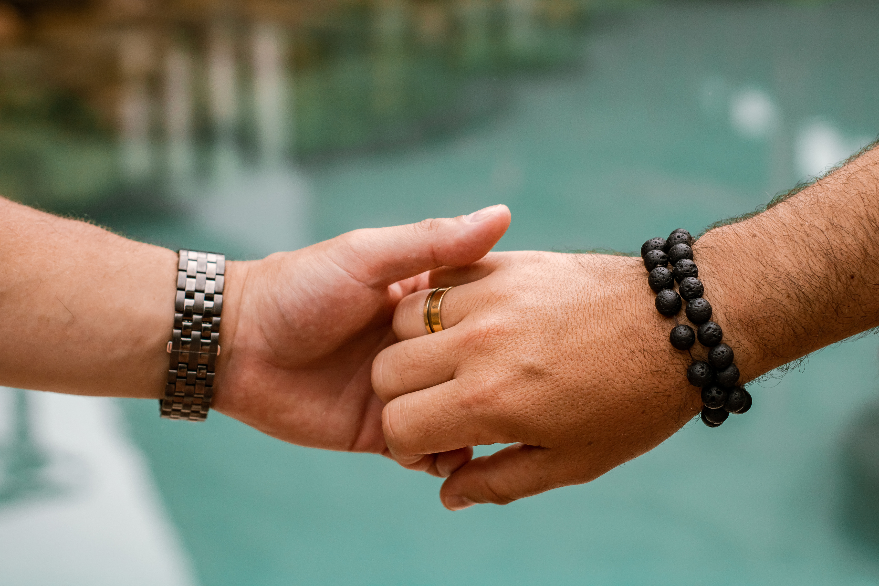 Crop unrecognizable gay couple holding hands in nature